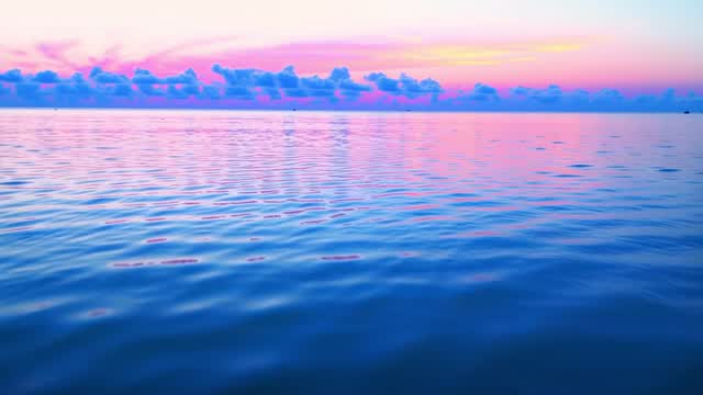 薄明の海に広がる色鮮やかな朝焼けと夕焼け雲 AI video preview