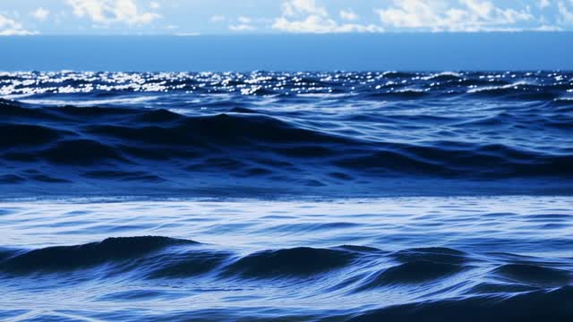 Deep blue ocean waves breaking on shore