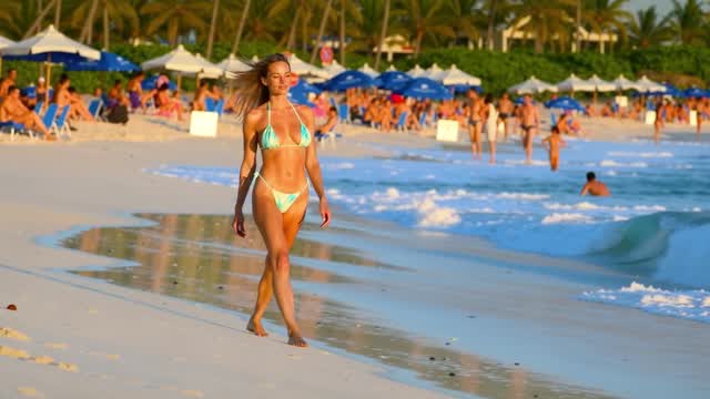 Woman strolling on sandy tropical beach at golden hour AI video preview