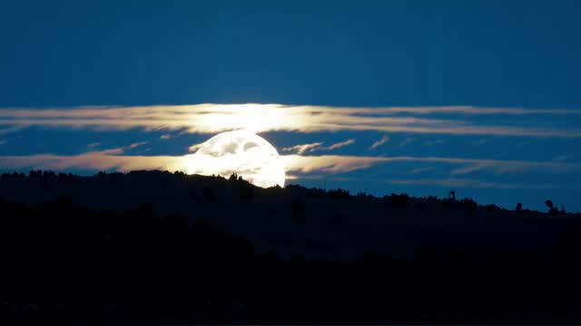Full moon illuminating mountains under cloudy sky AI video preview
