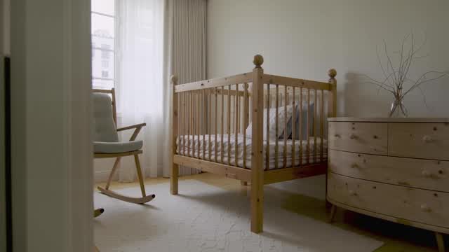Bright minimalist baby nursery room decor featuring wooden furniture AI video preview